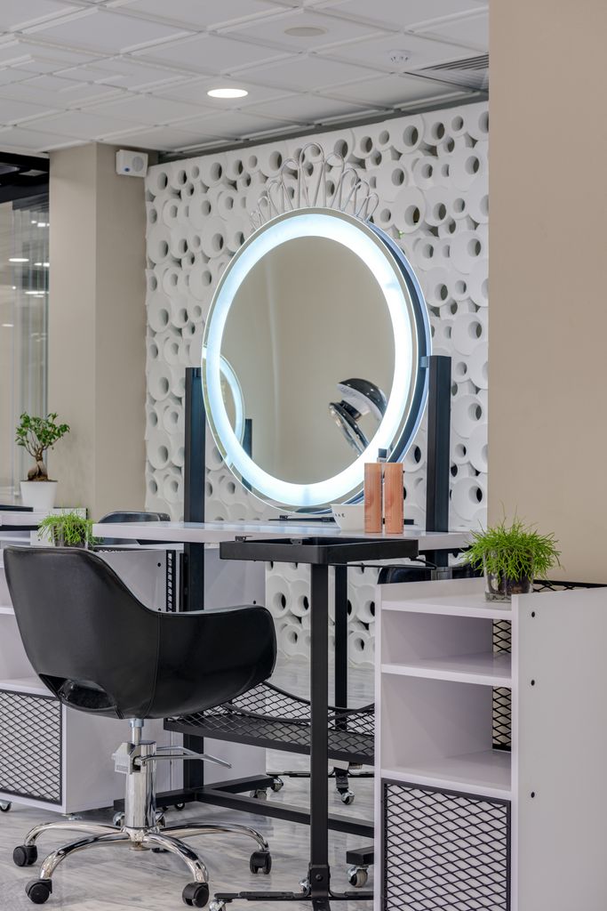 Elegant salon interior featuring a stylish setup with a ring light and mirror.